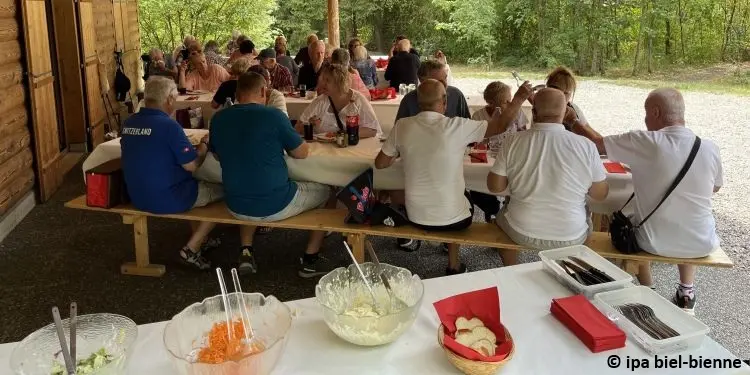 Membres assis à des tables vers la maison forestière